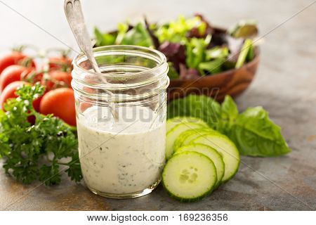 Homemade ranch dressing in a mason jar with fresh vegetables