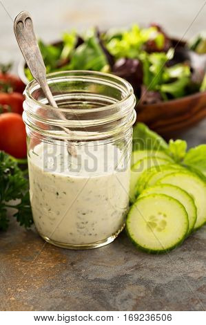Homemade ranch dressing in a mason jar with fresh vegetables