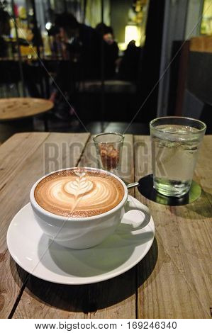 Coffee with latte art on the cafe table