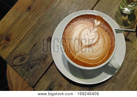 Coffee with latte art on the cafe table