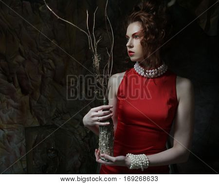 young luxury woman with bright makeup holding a bunch of dry twi