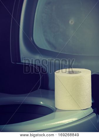 Open portable toilet bowl with paper roll