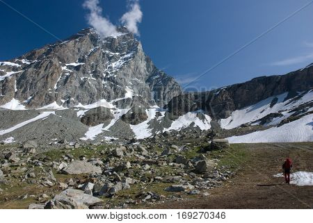Hiker walking below majestic Matterhorn mountain from Cervinia