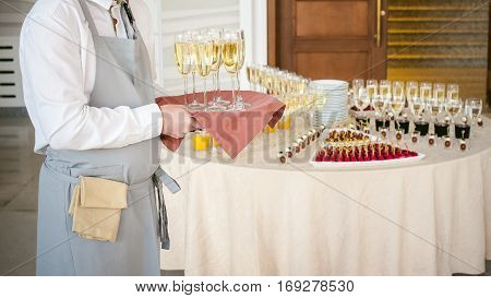 Waiter With A Tray Of Champagne In Hand On Background Fourchette Table