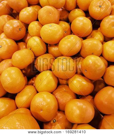 Mandarin oranges in fruit market. Fresh orange background.