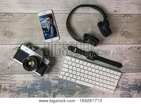 SWINDON UK - FEBRUARY 7 2017: Flat Lay with old SLR film camera iPhone Apple watch keyboard and headphones