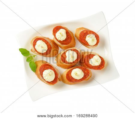 Bread based canapes with spicy sausage and creamy spread