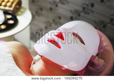 Photodynamic therapy facial mask on woman's face