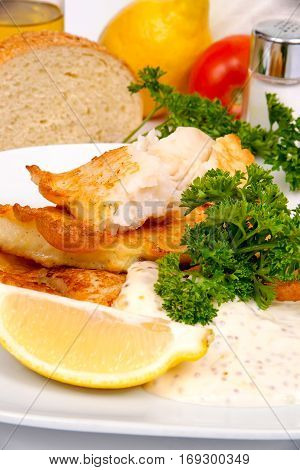 Perch in batter with herbs and spices on a white plate