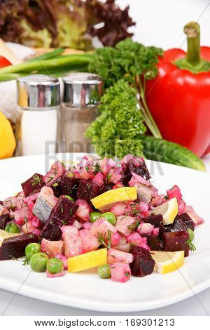 Beetroot salad with herring with a spicy sauce with spices on the white plate