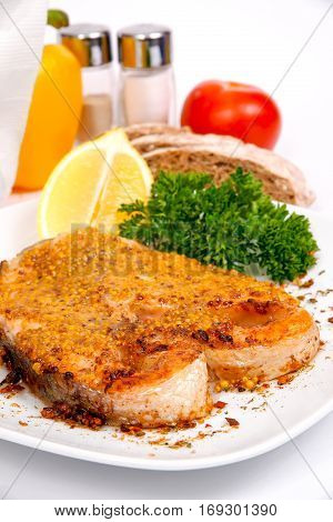salmon with spicy sauce on a white plate with greens