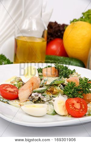 Catfish salad with mustard sauce with herbs on a white plate