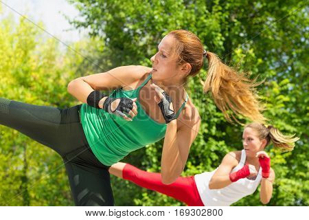 Two young women demonstrating side kicks in taebo training