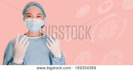 Portrait of surgeon woman reading for surgery against pink background