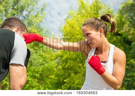 Instructor avoiding punches in TaeBo training. Focus on girl hand in motion blur