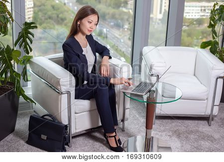 Young Asian Business Woman In Suit Working At A Laptop