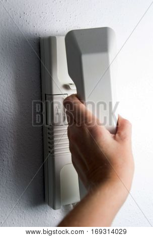 a Hand holding headphone of entry phone