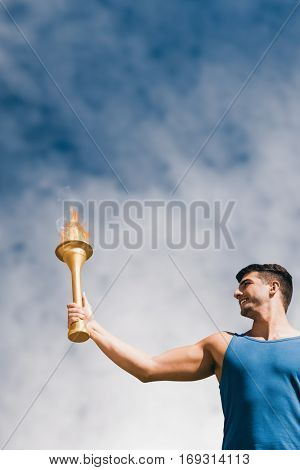 Low angle view of sportsman holding a cup against low angle view of sky