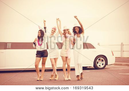 Happy friends dancing in front of limousine on night out