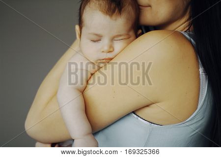little baby asleep in the arms of his mother. cute child, happy mother