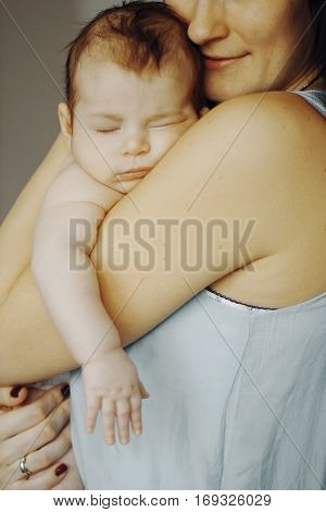 little baby asleep in the arms of his mother. cute child, happy mother