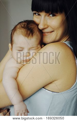 little baby asleep in the arms of his mother. cute child, happy mother