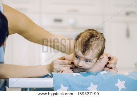 small child learns to help parents keep his head. baby lying on a blue diaper in a star. parental support.