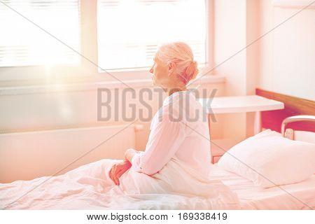 medicine, age, health care and people concept - senior woman patient lying in bed at hospital ward