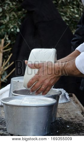 Hands of the elderly manufacturer of cheese