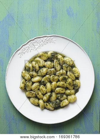 close up of rustic italian gnocchi in pesto sauce