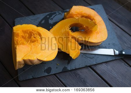 chopped pumpkin on a dark wooden table