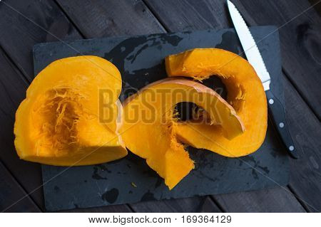 chopped pumpkin on a dark wooden table