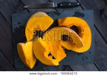 chopped pumpkin on a dark wooden table