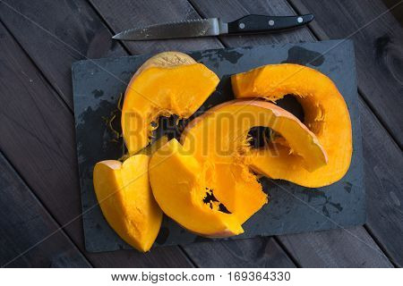 chopped pumpkin on a dark wooden table