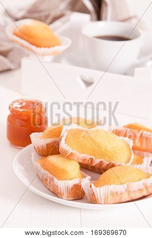 Breakfast with plumcake and apricot jam on wooden table.
