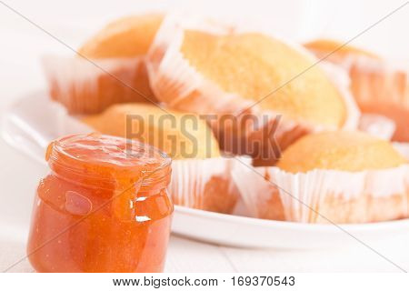 Breakfast with plumcake and apricot jam on white dish.