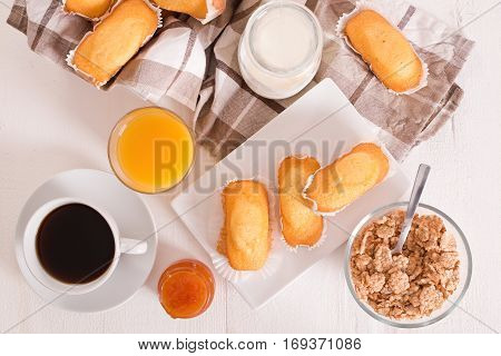Breakfast with plumcake and apricot jam on wooden table.