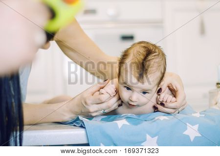 small child learns to help parents keep his head. baby lying on a blue diaper in a star. parental support.