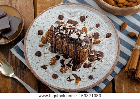 Piece of chocolate Spartak cake on a table. Delicious sweet food on a beautiful plate. Top view.