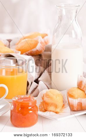 Breakfast with plumcake and apricot jam on wooden table.