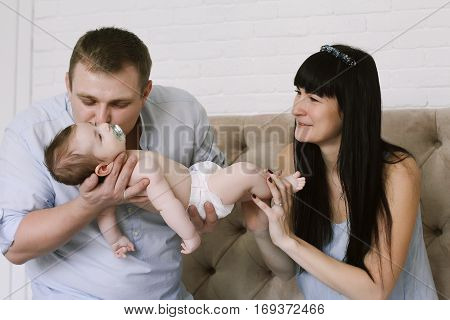 happy family consisting of mom and dad's baby boy. happy family relationships. mother entertains a child, his father holding him in his arms.