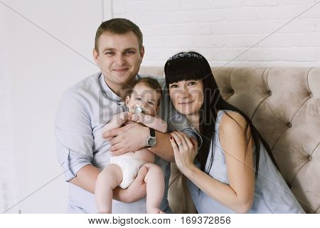 happy family consisting of mom and dad's baby boy. happy family relationships. mother entertains a child, his father holding him in his arms.