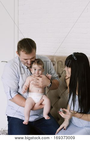 happy family consisting of mom and dad's baby boy. happy family relationships. mother entertains a child, his father holding him in his arms.