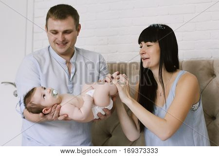 happy family consisting of mom and dad's baby boy. happy family relationships. mother entertains a child, his father holding him in his arms.