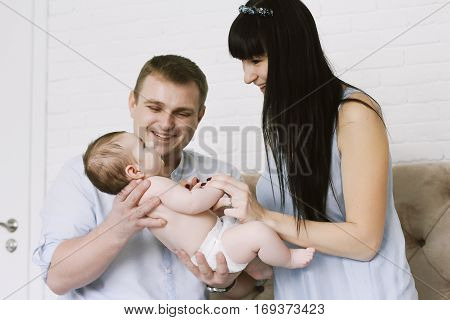 happy family consisting of mom and dad's baby boy. happy family relationships. mother entertains a child, his father holding him in his arms.