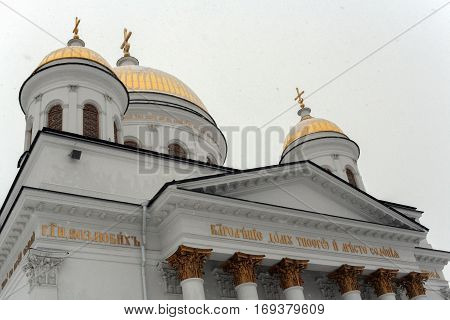 Orthodox temple. Golden domes of Novo-Tikhvinsky women monastery in Ekaterinburg at overcast snowy day in winter.