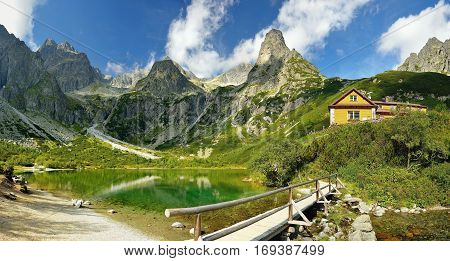 High Tatras in Slovakia. Green lake and monumental peaks. Summer scenic landscape mountain view. Green lake cottage.
