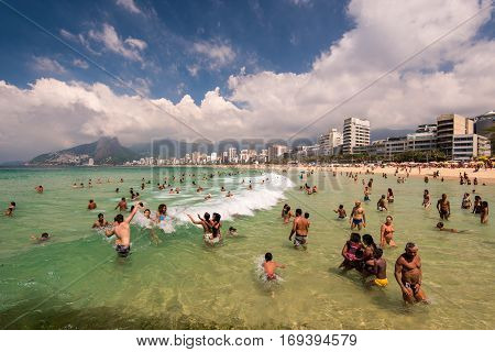 Rio de Janeiro, Brazil - January 15, 2017: Sunny summer day in Arpoador beach and the water is full of people enjoying waves.