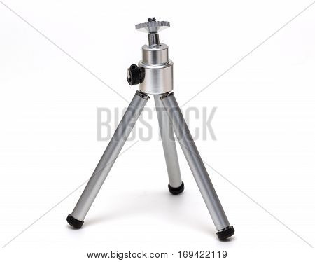 Miniature metal tripod isolated on white background