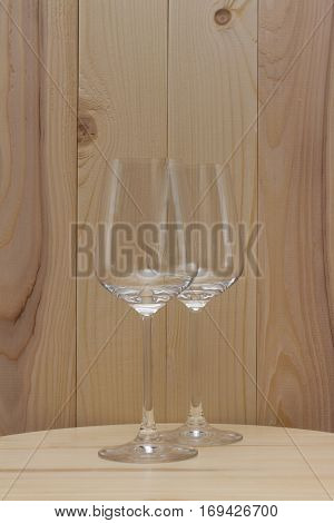 two transparent glass standing on a wooden stand with a wooden background